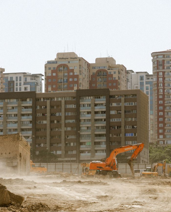 A construction site with excavators and apartment buildings in Baku, Azerbaijan.