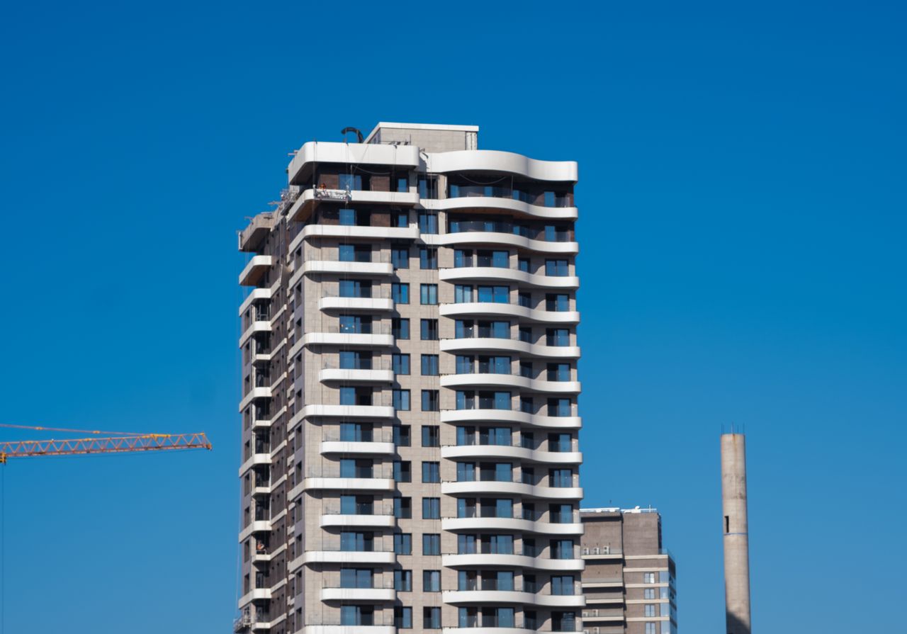About A view of a contemporary high-rise building against a clear blue sky in Bornova, İzmir, Türkiye.
